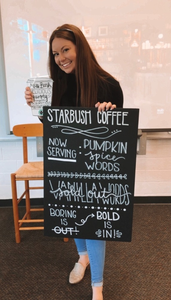 Teacher holding a fake coffee shop menu and posing for the camera